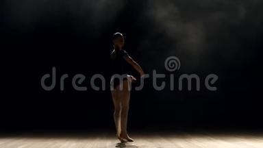 女芭蕾舞演员在黑暗中上台的剪影。